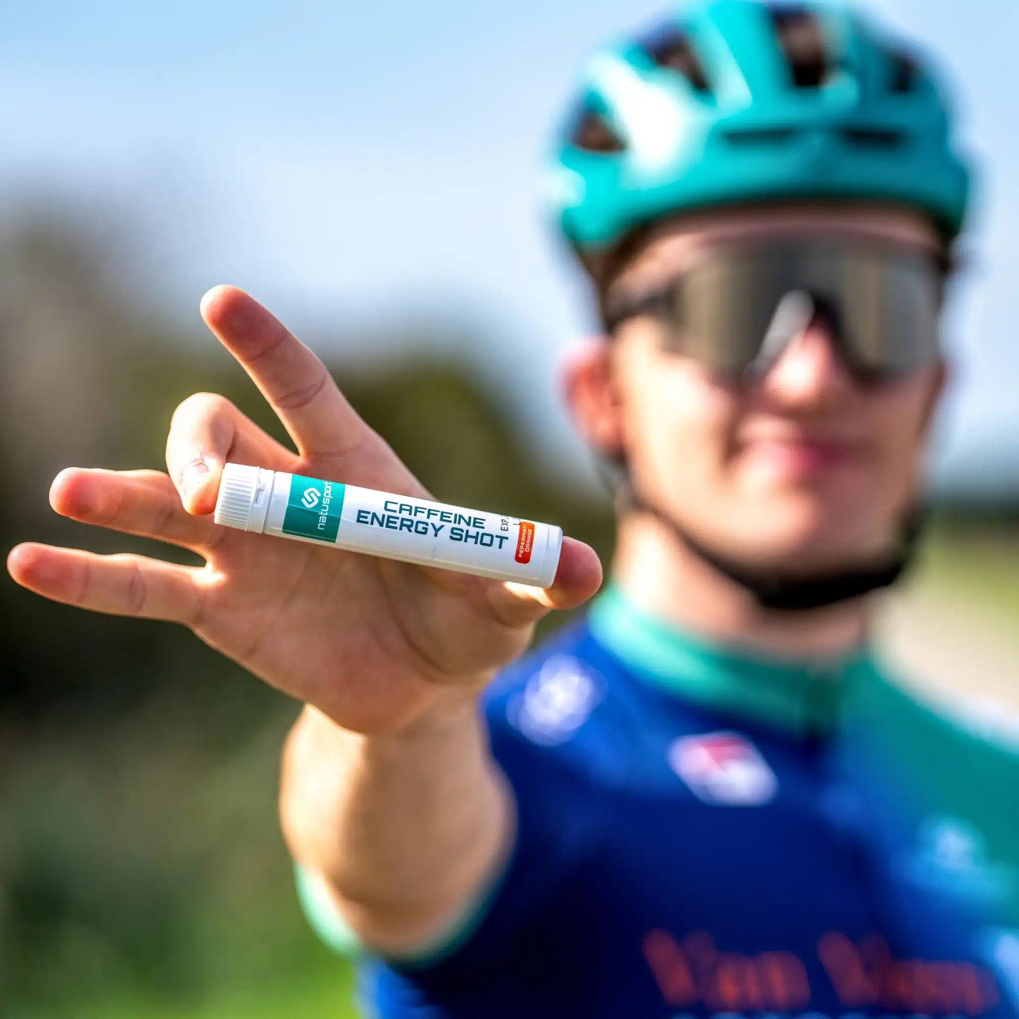 Natusport Caffeine Energy Shot in hand van wielrenner